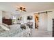 Light-filled bedroom featuring soft carpet, ceiling fan, barn door, and dresser at 5843 Ceylon St, Denver, CO 80249