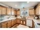 Functional kitchen featuring oak cabinets, tiled backsplash, and modern appliances at 5843 Ceylon St, Denver, CO 80249