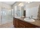 Bathroom with a double sink vanity, framed mirror, and glass-enclosed shower at 4561 Hope Cir, Broomfield, CO 80023