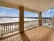 Deck overlooking a snowy landscape with brick pillars and wooden flooring at 2020 Alpine Dr, Erie, CO 80516