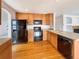 Kitchen with wood cabinets, black appliances, and hardwood floor at 2020 Alpine Dr, Erie, CO 80516