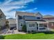 Spacious backyard featuring lush green grass, a covered patio, and outdoor seating at 4858 S Tibet St, Aurora, CO 80015