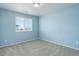 Bedroom featuring blue walls, carpet, and a single window at 4858 S Tibet St, Aurora, CO 80015