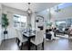 Open-concept space with a dining area featuring stylish furniture and a view of the living room with fireplace at 4858 S Tibet St, Aurora, CO 80015