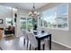 Elegant dining area with chandelier, table set for four, and large window with natural light at 4858 S Tibet St, Aurora, CO 80015