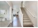 Inviting hallway with staircase and view into a beautifully decorated living space at 4858 S Tibet St, Aurora, CO 80015