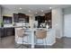 Kitchen island featuring granite countertops, pendant lighting, stainless appliances, and dark wood cabinets at 4858 S Tibet St, Aurora, CO 80015