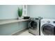 Functional laundry room with modern washer and dryer units, a countertop, and stylish decor at 4858 S Tibet St, Aurora, CO 80015