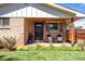 Inviting front porch with chairs, black door and brick exterior, great for relaxing at 4585 Hooker St, Denver, CO 80211