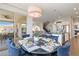 Bright dining room features a modern chandelier, blue upholstered chairs, and easy access to the outdoor patio at 9724 Cantabria Pt, Lone Tree, CO 80124