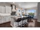 Modern kitchen with white cabinets, granite countertops, and a spacious island with barstool seating at 9724 Cantabria Pt, Lone Tree, CO 80124