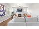 Bright living room features a modern fireplace, TV, light gray colored sofas and plantation shutters at 9724 Cantabria Pt, Lone Tree, CO 80124