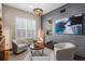 Stylish living room with a tiled wall, a modern chandelier, and comfortable armchairs at 9724 Cantabria Pt, Lone Tree, CO 80124