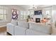 Bright living room with a modern fireplace, TV, light gray colored sofas and plantation shutters at 9724 Cantabria Pt, Lone Tree, CO 80124