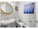 Stylish powder room features a pedestal sink, modern fixtures, and decorative artwork at 9724 Cantabria Pt, Lone Tree, CO 80124