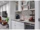 Wet bar features granite countertops, copper sink and backsplash with a beverage cooler at 9724 Cantabria Pt, Lone Tree, CO 80124