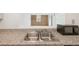 Modern kitchen features a double sink, granite countertops, and stainless-steel microwave at 2880 S Locust St # 109S, Denver, CO 80222