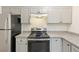 Well-lit kitchen featuring updated appliances, gray cabinets and speckled countertops at 2880 S Locust St # 109S, Denver, CO 80222