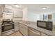 Bright kitchen with stainless steel appliances, speckled countertops, and tile flooring at 2880 S Locust St # 109S, Denver, CO 80222