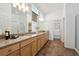 Bright bathroom with double vanity, granite counters, large mirrors, and a separate glass-enclosed shower at 8726 Holman Cir, Arvada, CO 80005