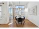 Light-filled dining area with modern chandelier, large windows, and sliding door access to the outside at 8726 Holman Cir, Arvada, CO 80005
