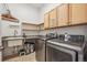 Functional laundry room with modern washer and dryer, storage cabinets, and a sink at 8726 Holman Cir, Arvada, CO 80005