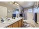 Bright bathroom with double sinks, wood cabinets, tub, and decorative accents at 1542 Cherry St, Brighton, CO 80601