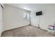 Cozy bedroom features plush carpet, window with blinds, and mounted TV at 1542 Cherry St, Brighton, CO 80601
