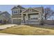 View of charming two-story home featuring a covered porch, stone accents, and well-maintained lawn at 1542 Cherry St, Brighton, CO 80601