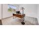Bright bedroom featuring a rustic desk with a modern lamp and view of the outdoors from a large picture window at 16673 E Virginia Ave, Aurora, CO 80017