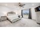 Spacious primary bedroom with a wooden bed frame, soft gray accents, and a view of the outdoors from a large window at 16673 E Virginia Ave, Aurora, CO 80017