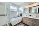 Modern bathroom with dual vanity, soaker tub, and tiled glass shower at 6530 S Tabor St, Littleton, CO 80127