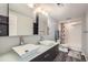 Modern bathroom featuring double sinks, sleek fixtures, a vanity with storage, and a shower with subway tile at 6530 S Tabor St, Littleton, CO 80127