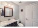 Powder room featuring wood-trimmed mirror, dark vanity, and white toilet at 6530 S Tabor St, Littleton, CO 80127