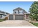 Two-story home featuring a three car garage, neutral paint, well maintained landscaping, and an American flag at 6530 S Tabor St, Littleton, CO 80127