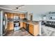 Open concept kitchen with oak cabinets, granite countertops, tile backsplash, and stainless steel appliances at 6530 S Tabor St, Littleton, CO 80127