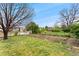 Fenced backyard featuring green grass, mature trees, and a garden area at 7333 S Dexter Way, Centennial, CO 80122
