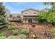 Landscaped backyard with a stone patio, a fire pit, a pergola, and a lush garden at 7333 S Dexter Way, Centennial, CO 80122