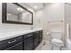 Bathroom featuring dark vanity with large mirror and toilet at 7333 S Dexter Way, Centennial, CO 80122