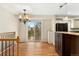 Chandelier-lit dining area with access to a deck, and an open layout flowing into a kitchen area at 7333 S Dexter Way, Centennial, CO 80122