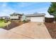 View of the two story home, driveway, and surrounding foliage at 7333 S Dexter Way, Centennial, CO 80122