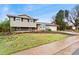 Two story home featuring stone accents, a two car garage and partially grass front yard at 7333 S Dexter Way, Centennial, CO 80122