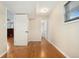 Basement hallway featuring hardwood floors, access to the utility room, and connecting living areas at 7333 S Dexter Way, Centennial, CO 80122