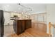 Open-concept kitchen with breakfast bar, wood floors, and natural light pouring in from the adjacent dining area at 7333 S Dexter Way, Centennial, CO 80122