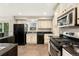 Kitchen with white cabinets, dark countertops and black appliances at 7333 S Dexter Way, Centennial, CO 80122