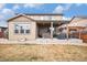 A backyard featuring a patio with a hot tub, pergola, and outdoor seating on a grassy lot at 25064 E Archer Pl, Aurora, CO 80018