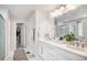 This bright bathroom features dual sinks, white cabinets and a large mirror, plus walk in closet at 25064 E Archer Pl, Aurora, CO 80018