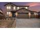 Charming two-story home boasts a stone facade and a three-car garage with ample parking at 25064 E Archer Pl, Aurora, CO 80018