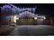 Night view of a beautiful two-story home with a stone facade and lighted garage, creating a welcoming ambiance at 25064 E Archer Pl, Aurora, CO 80018