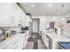 Modern kitchen with white cabinets, granite countertops, and stainless steel appliances at 25064 E Archer Pl, Aurora, CO 80018